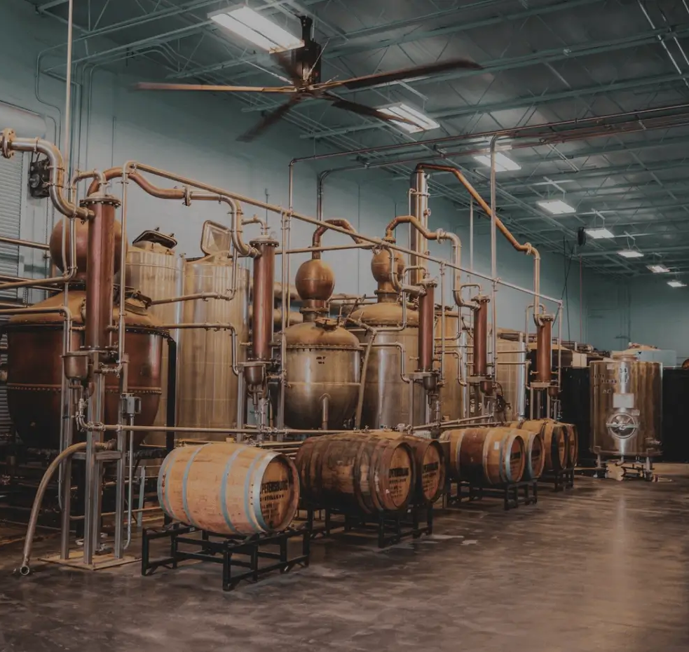 A room full of barrels and tanks in a distillery.