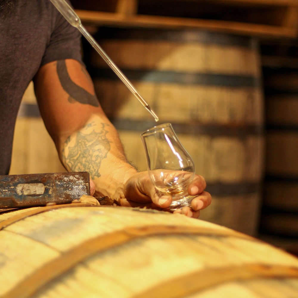 A person pouring a drink into a glass.